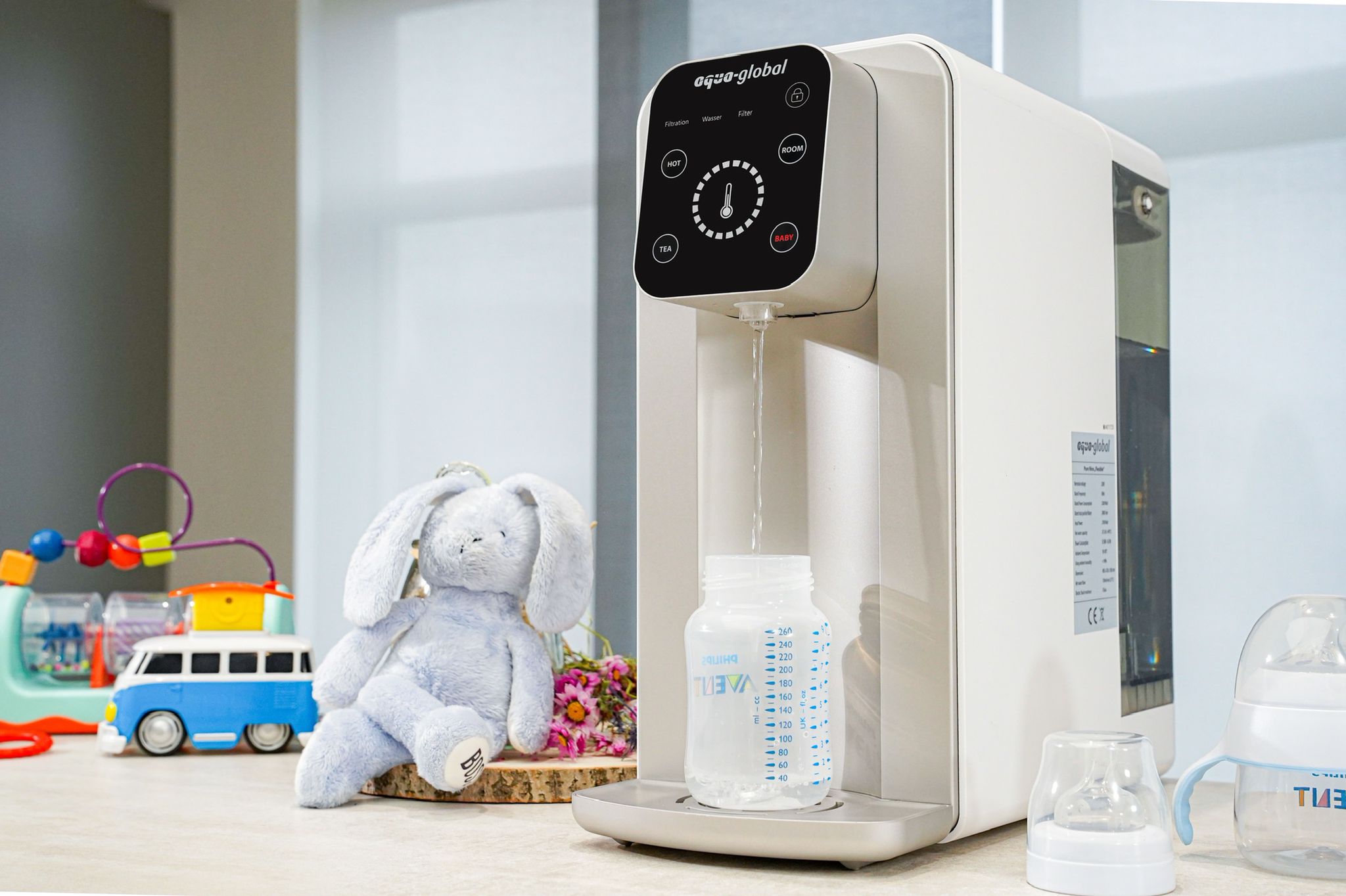 Aqua Global Wasseraufbereitungssystem mit Babyflasche in der Küche